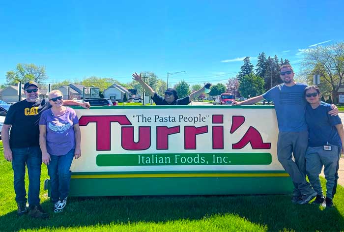 happy-turris-employees-by-marquee-sign
